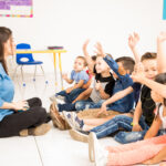 Preschool students raising their hands