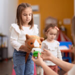 Two little girls playing with toys at kindergarten